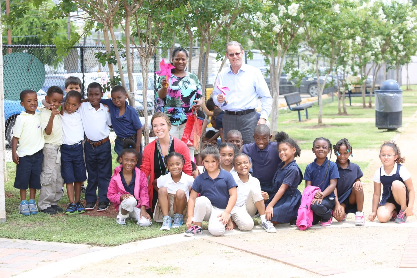 David Goswick with students and educators outdoors, holding handmade pinwheels.
